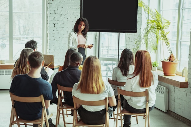 female-african-american-speaker-giving-presentation-hall-university-workshop_155003-3579