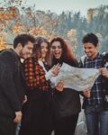 group-young-people-are-looking-map-where-they-are-while-walking-autumn-forest_613910-15159